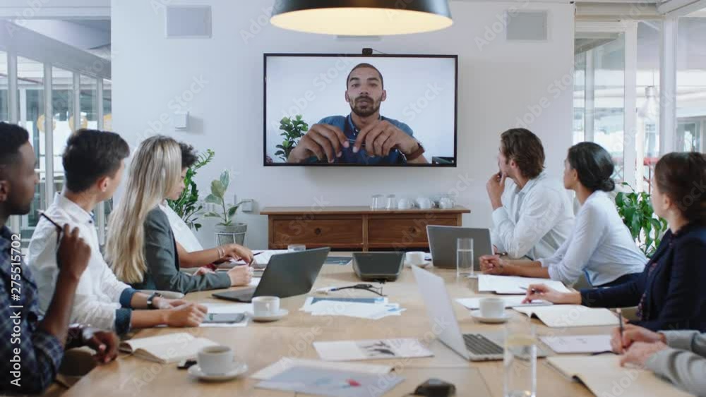 group of business people having conference call meeting in boardroom team leader man chatting to colleagues using online video chat on tv screen discussing ideas in office 4k