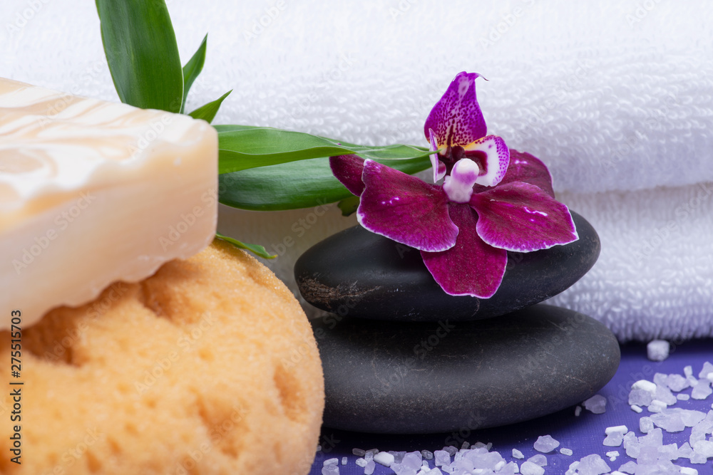 Spa Wellness Concept. Natural Foam Bath&Shower Sea Sponge, Almond Goat's milk Soap, Basalt Stones, Bamboo and Orchid Flower on purple background. Spa Wellness Concept. Natural Foam Bath&Shower Sea Sponge, Almond Goat's milk Soap, Basalt Stones, Bamboo and Orchid Flower on purple background.