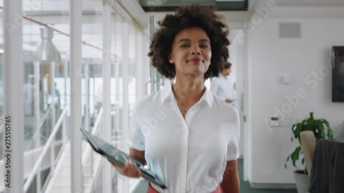 mixed race business woman smiling walking through office holding tablet computer enjoying successful career in corporate workplace 4k  