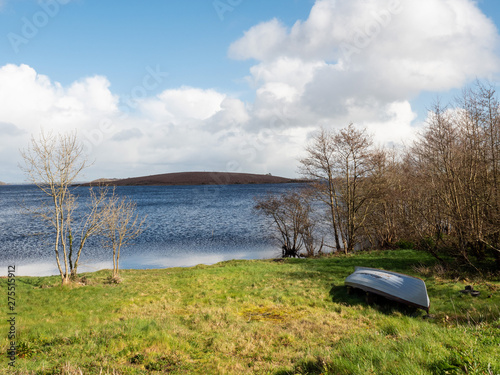 Fishing boat by a lake on a sunny day, Small island in the background. Lough Corrib, county Galway, Ireland,