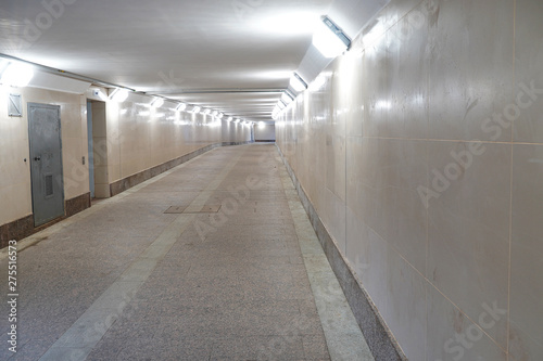 A pedestrian tunnel is empty without people. Underpass with light. Beige color.