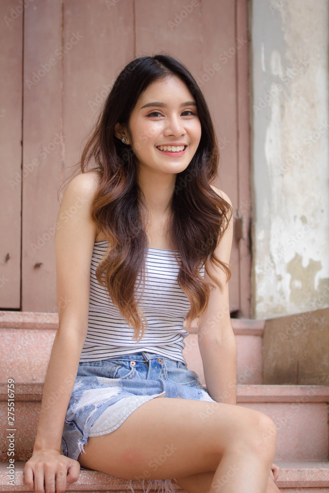 Portrait of thai adult beautiful girl White shirt blue jeans relax time Portrait of thai adult beautiful girl White shirt blue jeans relax time