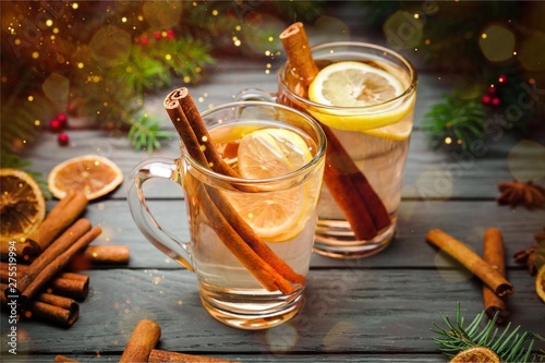 Mulled white wine with cinnamon in glasses on wooden background photo