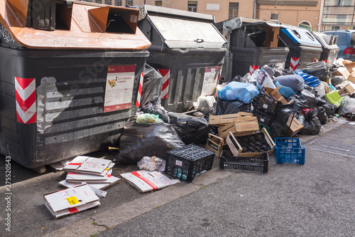 rows of garbage containers with trash and package on the street in Rome in Italy photo