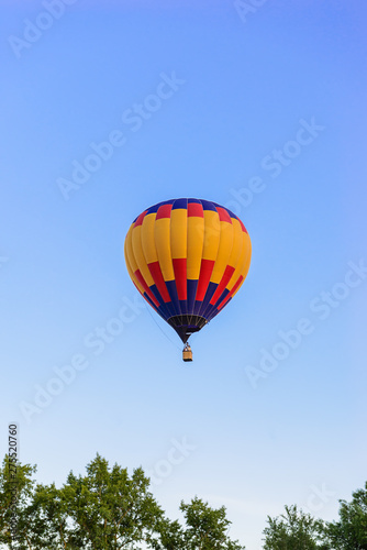 Colorful hot air balloon on the background blue sky. © 7707601