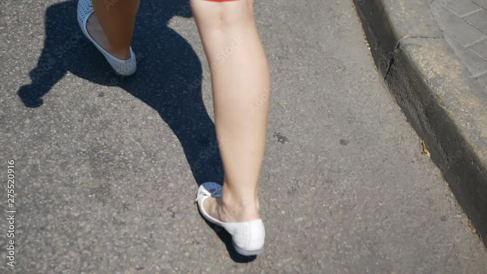 Female legs walking along a city street. The legs of a young business woman, the girl comes to work. Female legs walking along a city street. The legs of a young business woman, the girl comes to work.