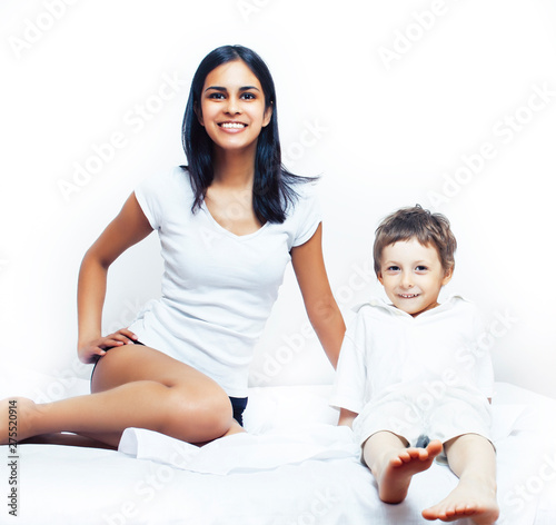 cute little boy in bed with mother in pajamas having fun happy smiling, lifestyle people concept