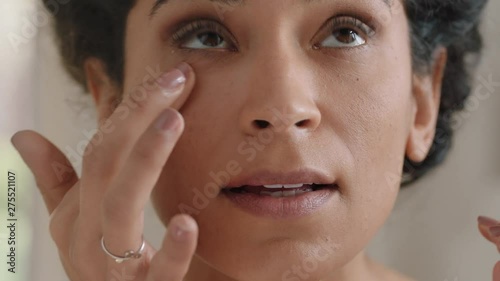 portrait beautiful young woman looking in mirror at perfect healthy skin touching face with hands enjoying smooth natural complexion with anti aging skincare getting ready at home beauty concept