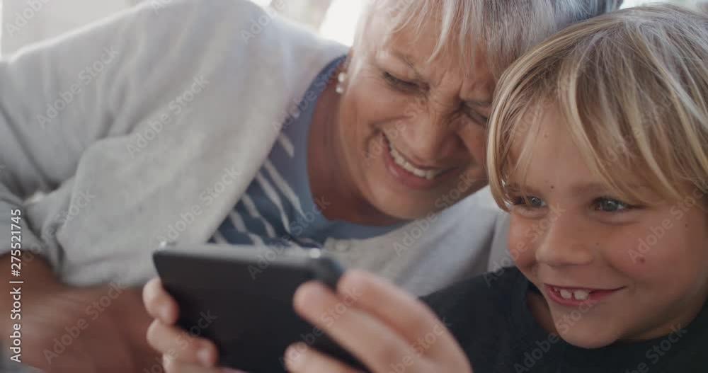happy grandmother watching little boy playing games on smartphone kid showing how to use mobile phone teaching granny modern technology at home 4k happy grandmother watching little boy playing games on smartphone kid showing how to use mobile phone teaching granny modern technology at home 4k