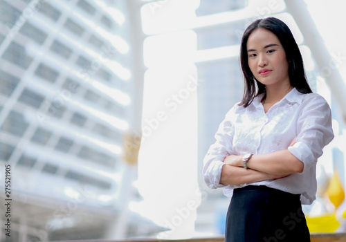 Asian beautiful business girl with white shirt act as confident and stand among high building in big city in day time. Free Download Asian beautiful business girl with white shirt act as confident and stand among high building in big city in day time. - GFXLoad
