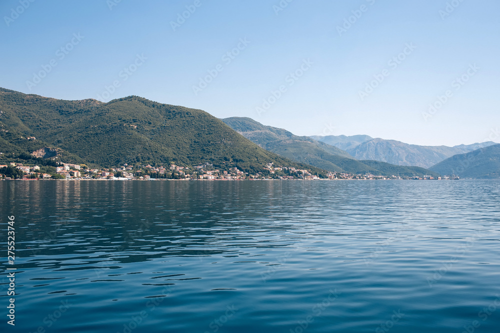 Seascape of the Adriatic Sea. The sea with mountains and mountains in the background. Boat sailing on the sea. Italy, Montenegro, Adriatic tourism