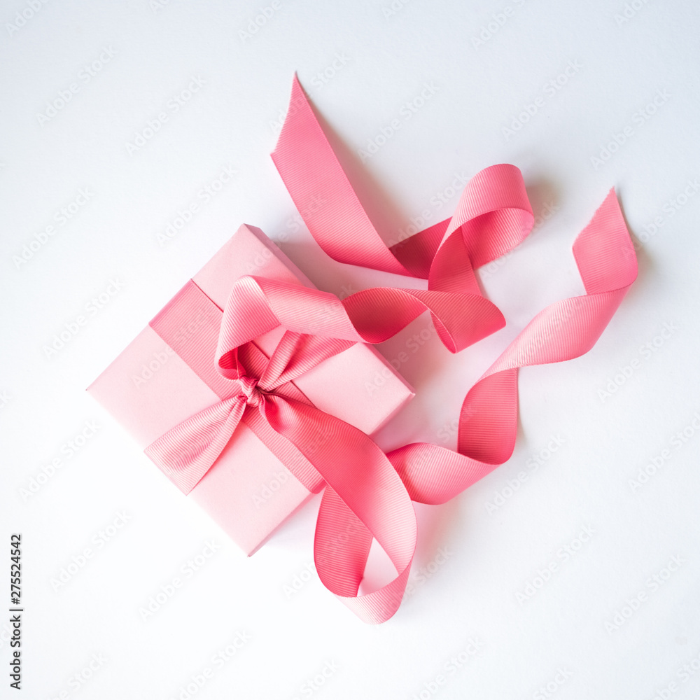 Pink gift box with a pink ribbon on a white background . Pink gift box with a pink ribbon on a white background .