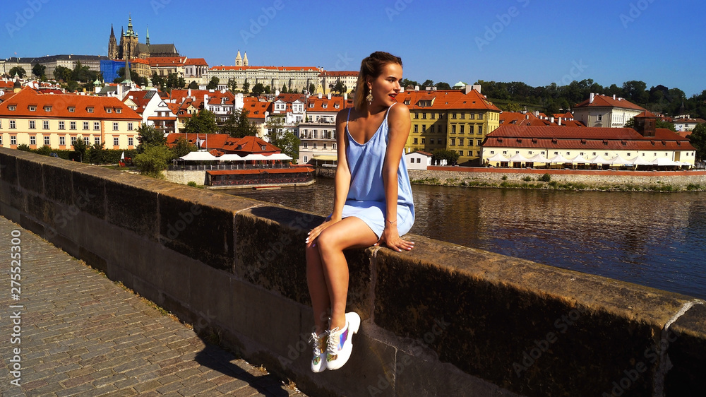 Young beautiful girl posing in bright sunlight on the Charles Bridge 