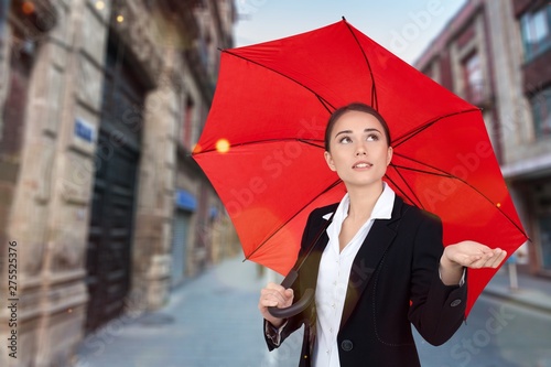 Beautiful young woman with red umbrella on streeet of modern city photo