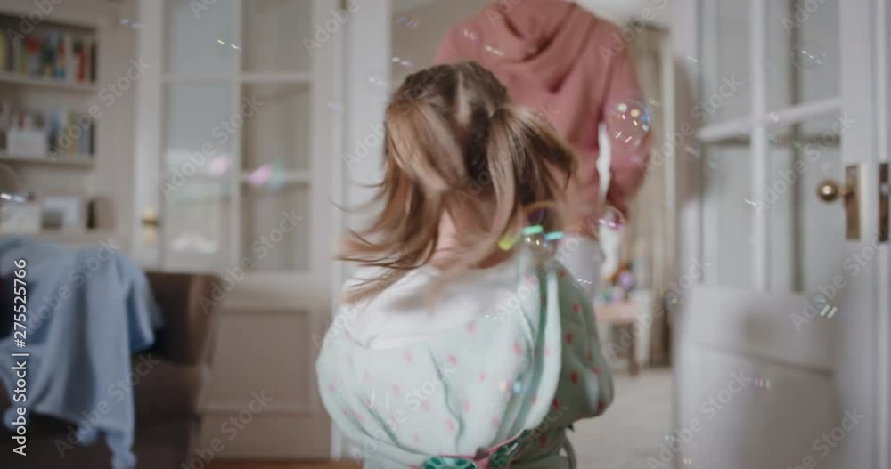 playful little girl blowing bubbles chasing mother with toy gun running through house playing catch happy mom enjoying fun game with daughter enjoying weekend morning 4k footage playful little girl blowing bubbles chasing mother with toy gun running through house playing catch happy mom enjoying fun game with daughter enjoying weekend morning 4k footage