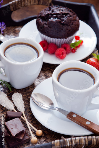 Black coffee in white cups and chocolate muffin for breakfast