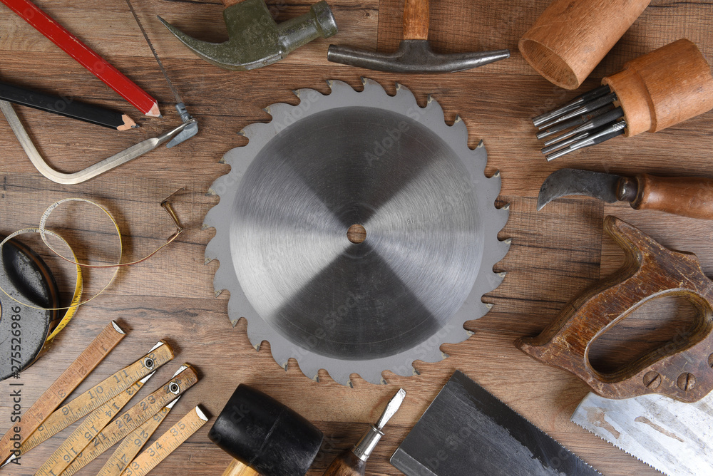 High angle closeup of a large group of tools arranged around a round table saw blade - obrazy, fototapety, plakaty 