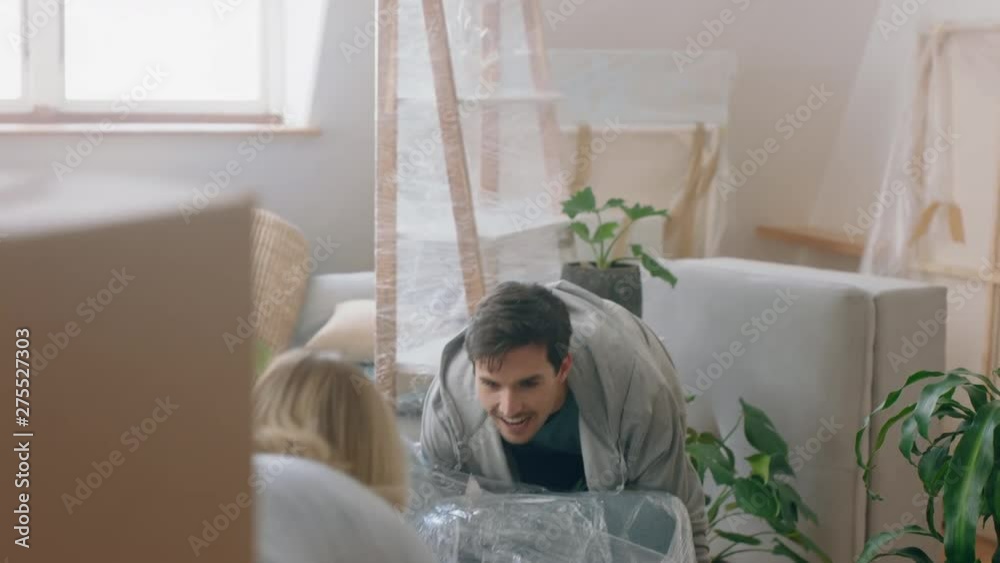 young couple moving into new house together carrying furniture relaxing on sofa resting after successful move enjoying teamwork 4k footage