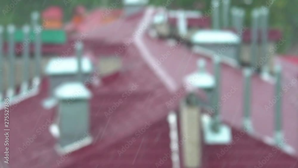 Powerful torrential rain hit the city. Drops of rain fall on the roof of the house located among the green trees. Climate change. Weather forecast. Blurred background Powerful torrential rain hit the city. Drops of rain fall on the roof of the house located among the green trees. Climate change. Weather forecast. Blurred background