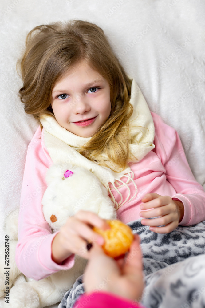 A sick little girl takes medication and eats fruit. A sick little girl takes medication and eats fruit.
