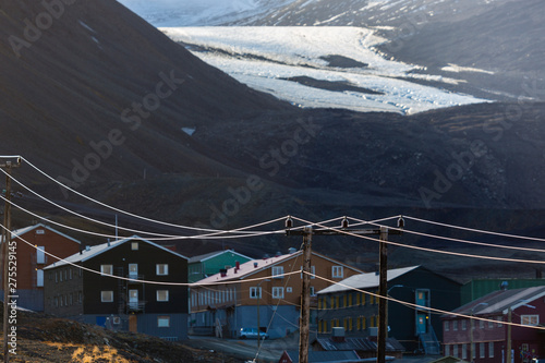 overview of longyearbyen, colored houses, power line with mountains and glacier in the background, svalbard, norway photo