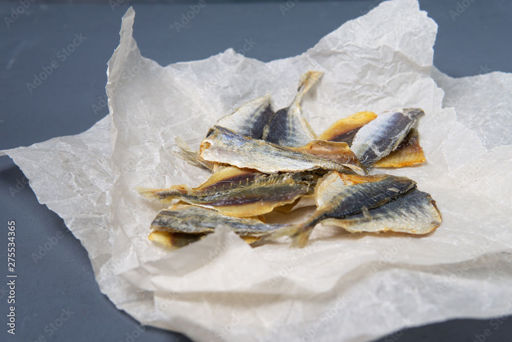 Salted fish lies in unfolded paper.