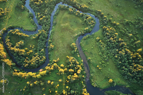 Forest with a winding river at sunset. Aerial photography with a drone.