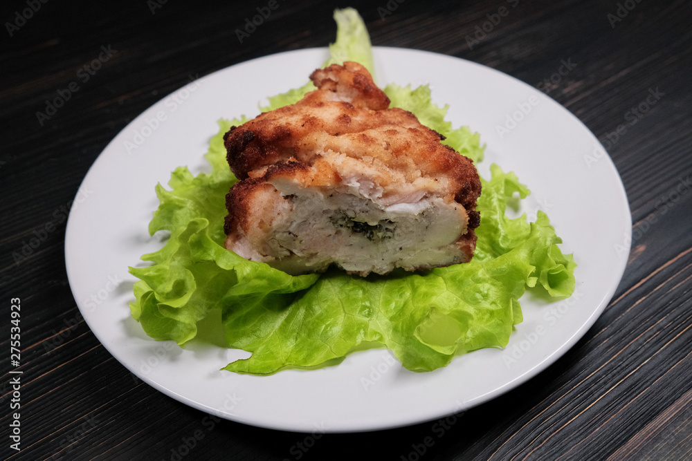 Cutlet on a green sheet close-up. Chops from chicken breast with lettuce leaves. Homemade cutlet on a white plate. Cutlet on a green sheet close-up. Chops from chicken breast with lettuce leaves. Homemade cutlet on a white plate.