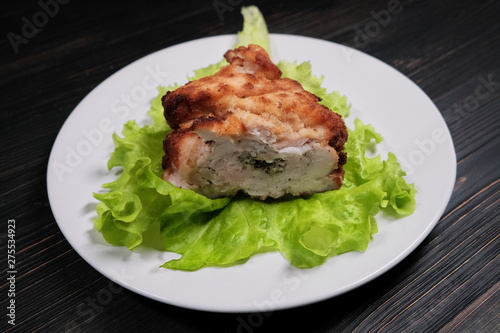 Cutlet on a green sheet close-up. Chops from chicken breast with lettuce leaves. Homemade cutlet on a white plate.