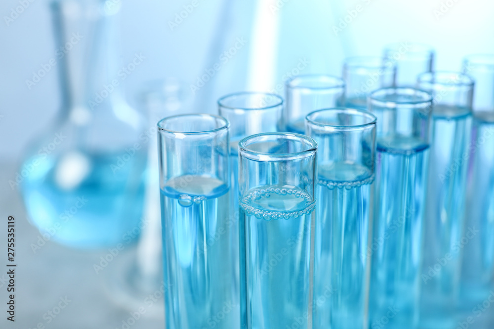 Test tubes with liquid on blurred background, closeup with space for text. Solution chemistry Test tubes with liquid on blurred background, closeup with space for text. Solution chemistry
