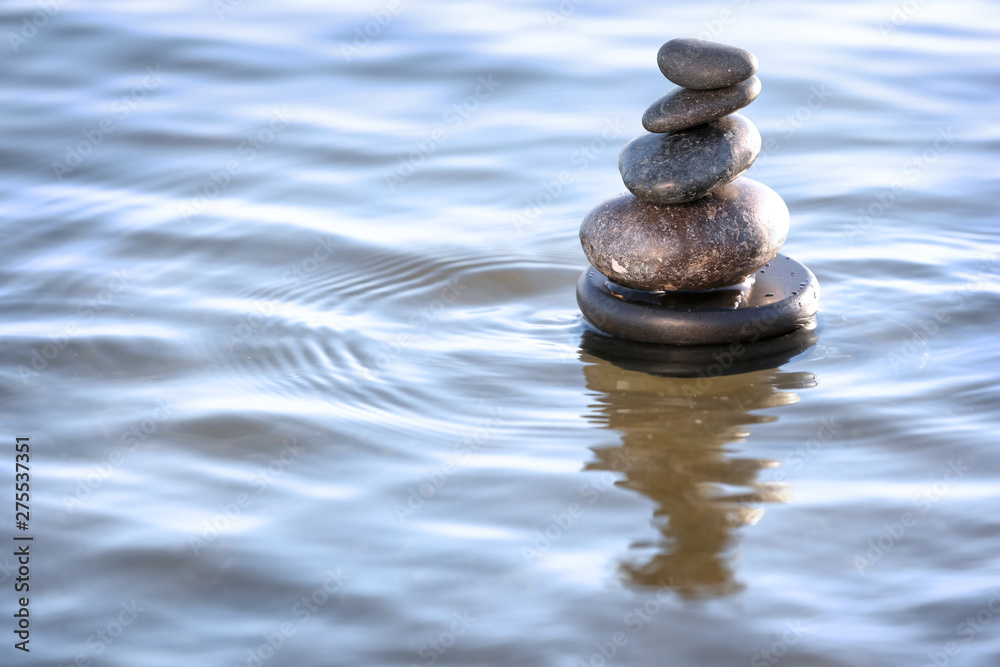 Stack of dark stones in sea water, space for text. Zen concept Stack of dark stones in sea water, space for text. Zen concept