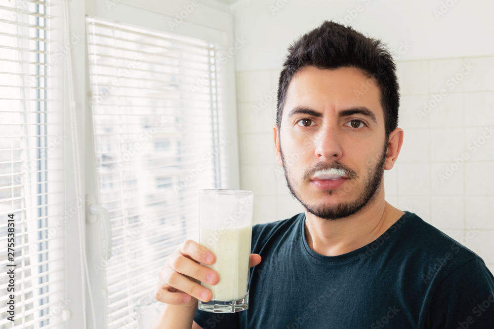 A young man prepared himself for breakfast a smoothie of vegetable milk and fresh fruit. He leads a healthy lifestyle. A young man prepared himself for breakfast a smoothie of vegetable milk and fresh fruit. He leads a healthy lifestyle.