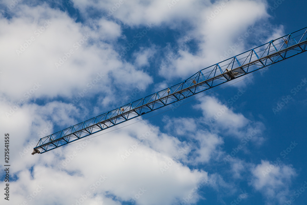 Arrow of a tower crane against a cloudy sky