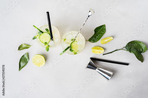Fototapeta Naklejka Na Ścianę i Meble -  Top view of Fresh Summer Healthy homemade mojito lemonade or cocktail with cucumber garnished with a cucumber slice, lime, sprouts and micro greens.
