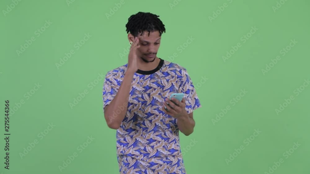 Stressed young African man using phone and getting bad news Stressed young African man using phone and getting bad news