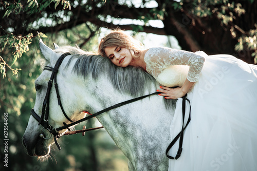 Beautiful and stunning bride, riding a horse in the nature