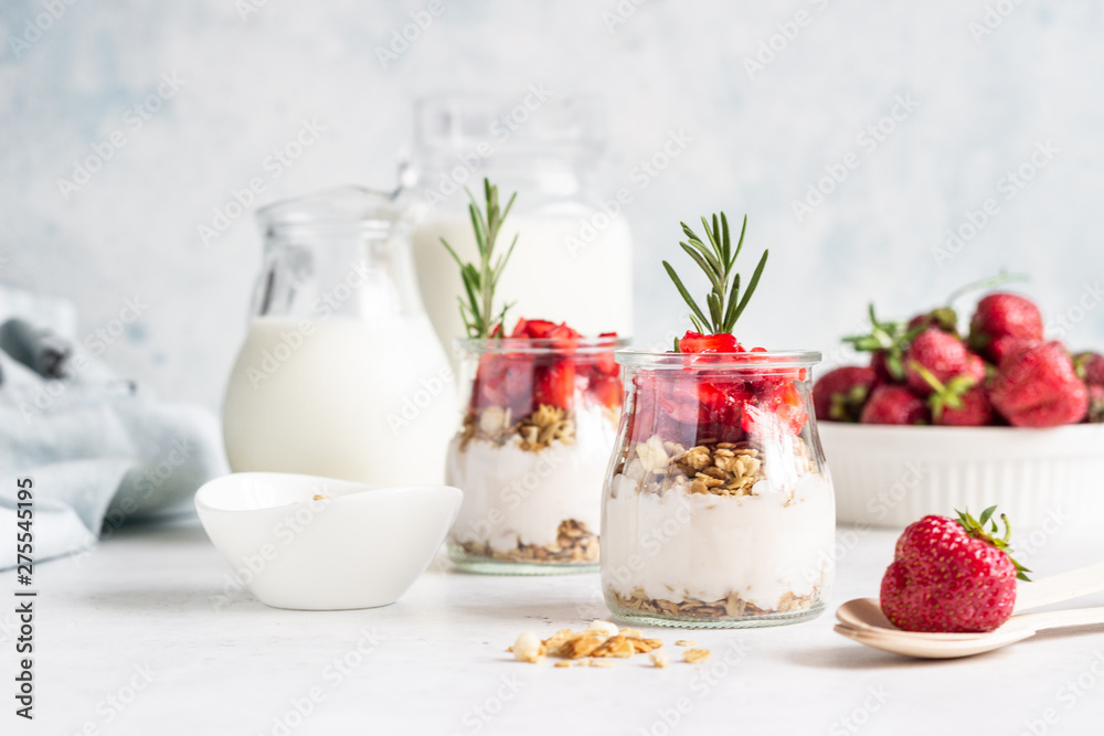 Berry yogurt with greek yogurt, fresh strawberries and granola in jars. Healthy breakfast parfait in glass cup. Copy space for text. Berry yogurt with greek yogurt, fresh strawberries and granola in jars. Healthy breakfast parfait in glass cup. Copy space for text.