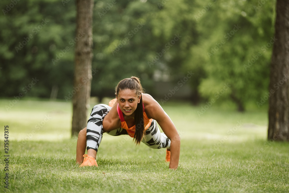 A beautiful fitness girl trains in the park