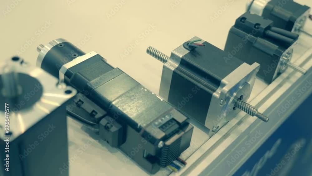 Varied in size and power stepper servomotor are presented at the exhibition on a white background. Shot in motion Varied in size and power stepper servomotor are presented at the exhibition on a white background. Shot in motion