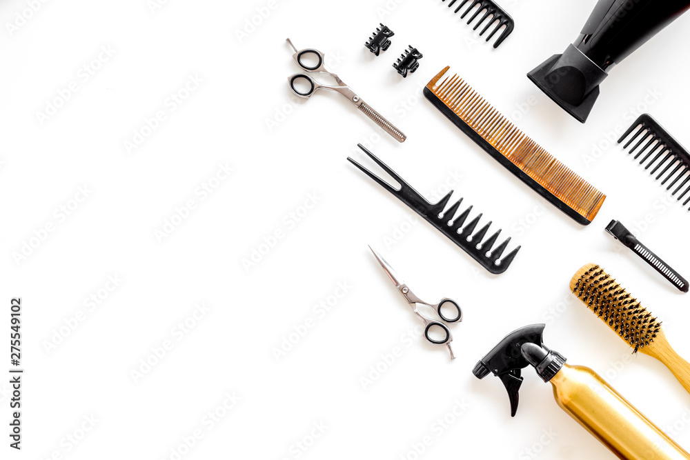 Combs, sciccors and hairdresser tools in beauty salon work desk on white background top view space for text
