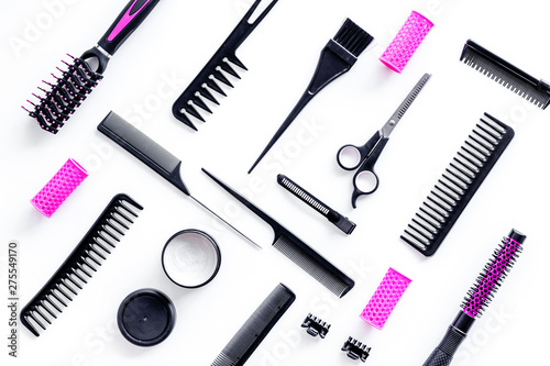 Combs, sciccors and pink hairdresser tools in beauty salon work desk on white background top view pattern