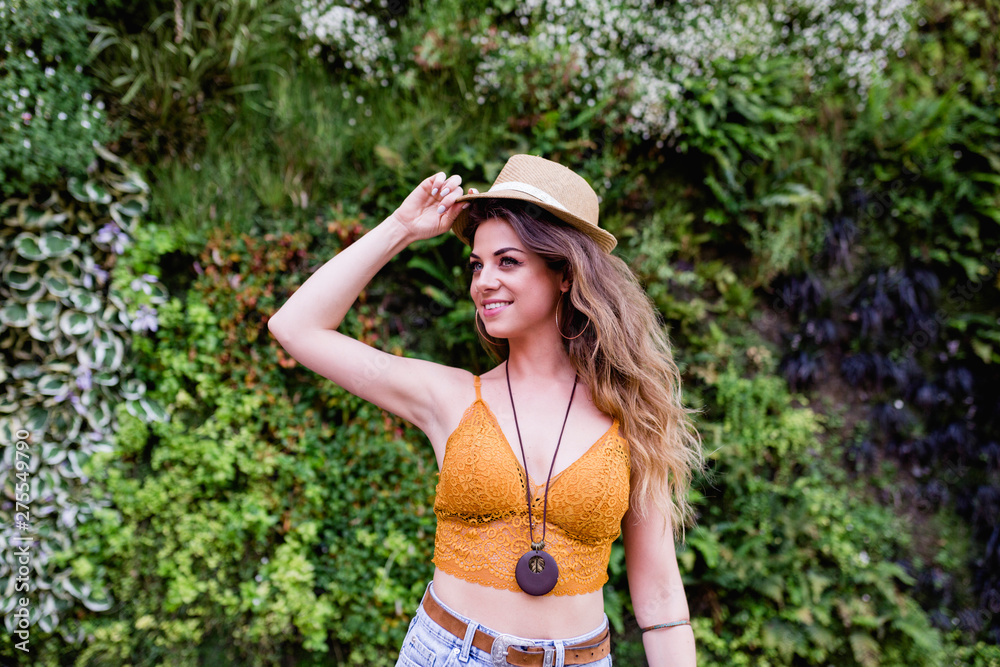 portrait of a young blonde beautiful woman at the street smiling. Green vegetation background. Lifestyle outdoors. Summertime