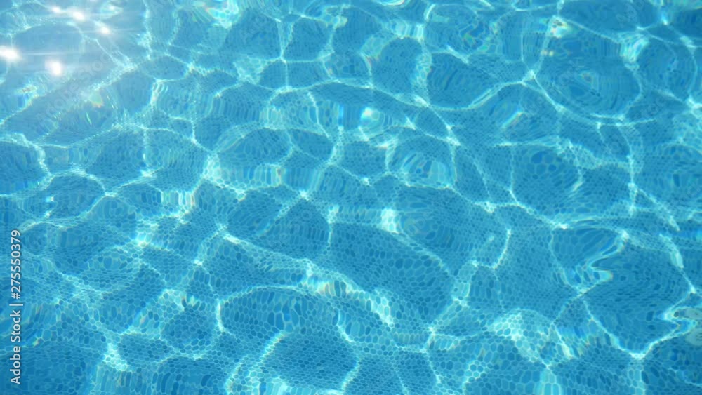 Glowing water playing in a swimming pool on a sunny day in summer in slo-mo Glowing water playing in a swimming pool on a sunny day in summer in slo-mo