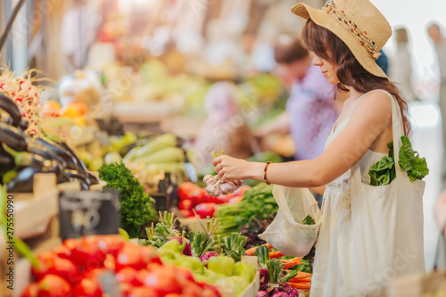 Fotografia Woman is chooses  fruits and vegetables at food market
