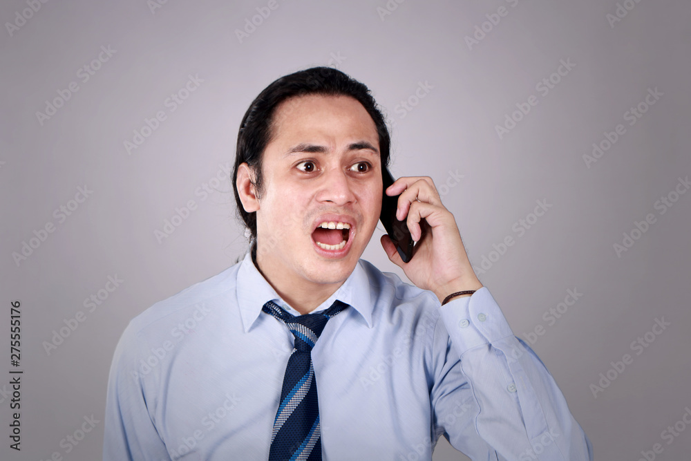 Young Man Talking on Phone, Shocked Worried Expression Young Man Talking on Phone, Shocked Worried Expression