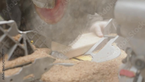 Woodworker cutting wood using a chop saw. photo