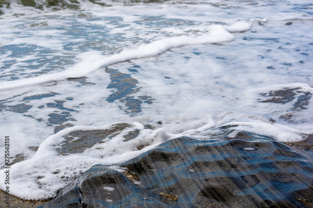 pebble stones on the sea beach, the rolling waves of the sea with foam pebble stones on the sea beach, the rolling waves of the sea with foam