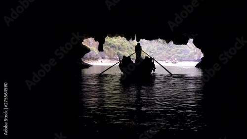 Tourists in traditional local boats being guided through the caves of the limestone islands of Ha Long Bay, Cat Ba National Park, Vietnam