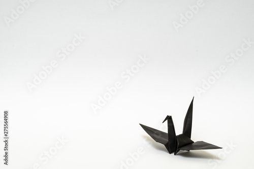 black origami paper crane on white background
