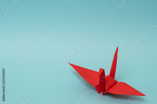 red origami paper crane on sky blue background